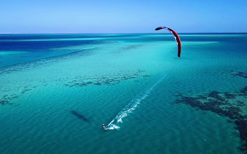 Helderblauwe zee met kitesurfer