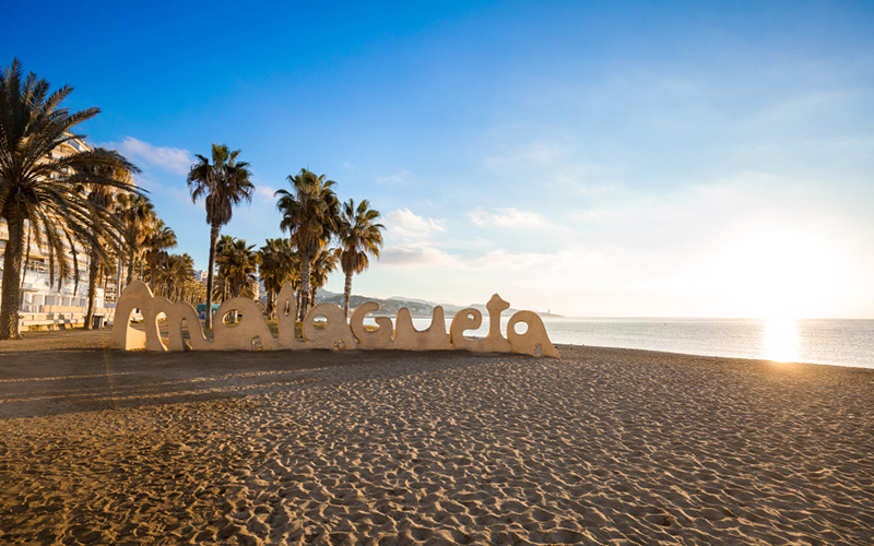 Strand met palmbomen en de letters Malagueta