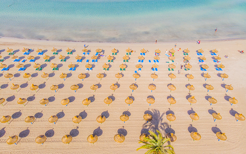 Het strand van El Arenal met allemaal parasols naast elkaar