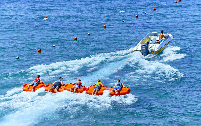 Jongeren op een funtube aan een speedboot
