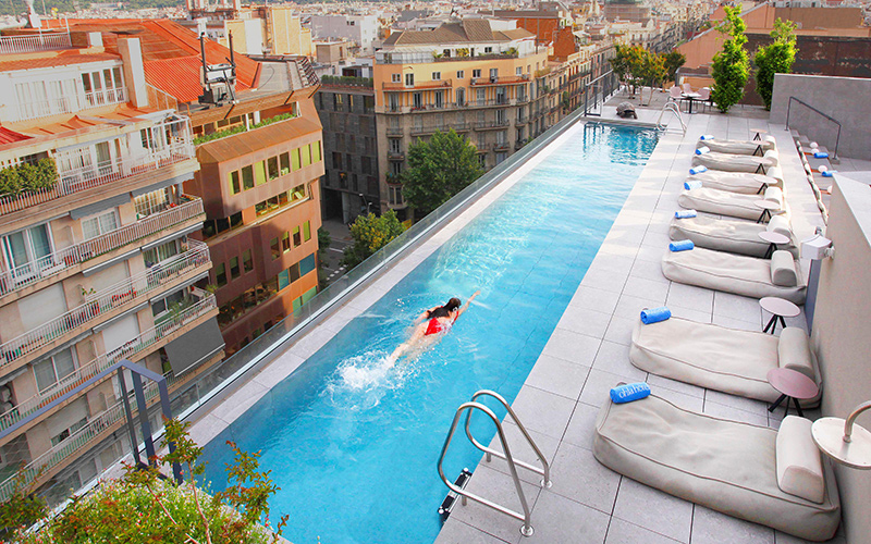 Een vrouw in het zwembad van Hotel Ohla Eixample in Barcelona