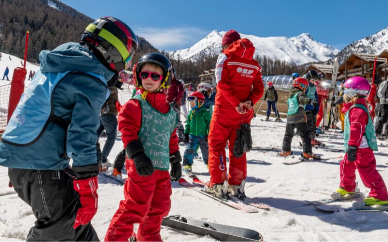 leerling praat met skileraar in groep tijdens famfun wintersport met sunweb