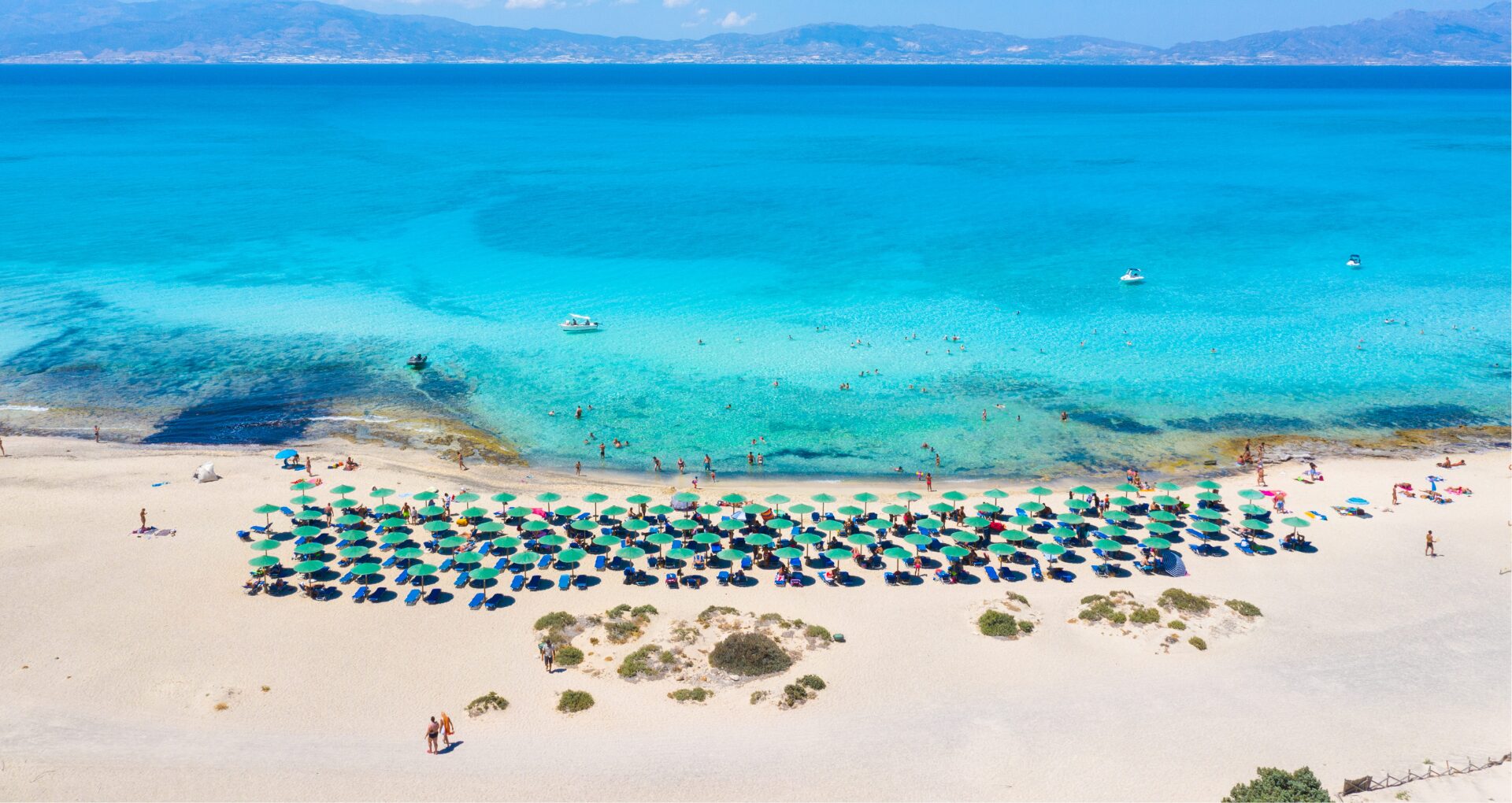 golden beach op chrissy island met parasols op wit strand en azuurblauwe zee