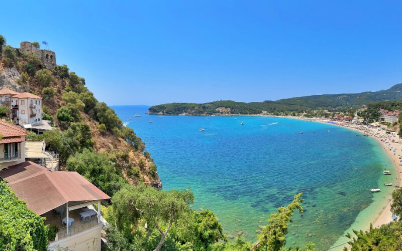 de baai van Valtos Beach in Parga Epirus Griekenland met helderblauw water en huisjes op de berghelling