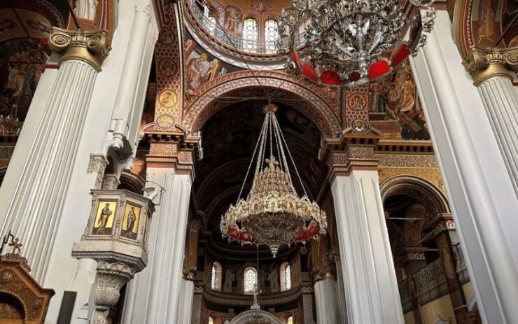 Interieur van de Agios Minas-kathedraal in Heraklion, Kreta, met prachtige iconen, grote zuilen en sierlijke kroonluchters.