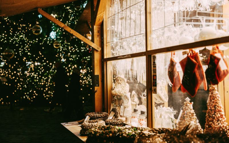 Kerstmarkt kraam met decoraties, ornamenten en lichten.
